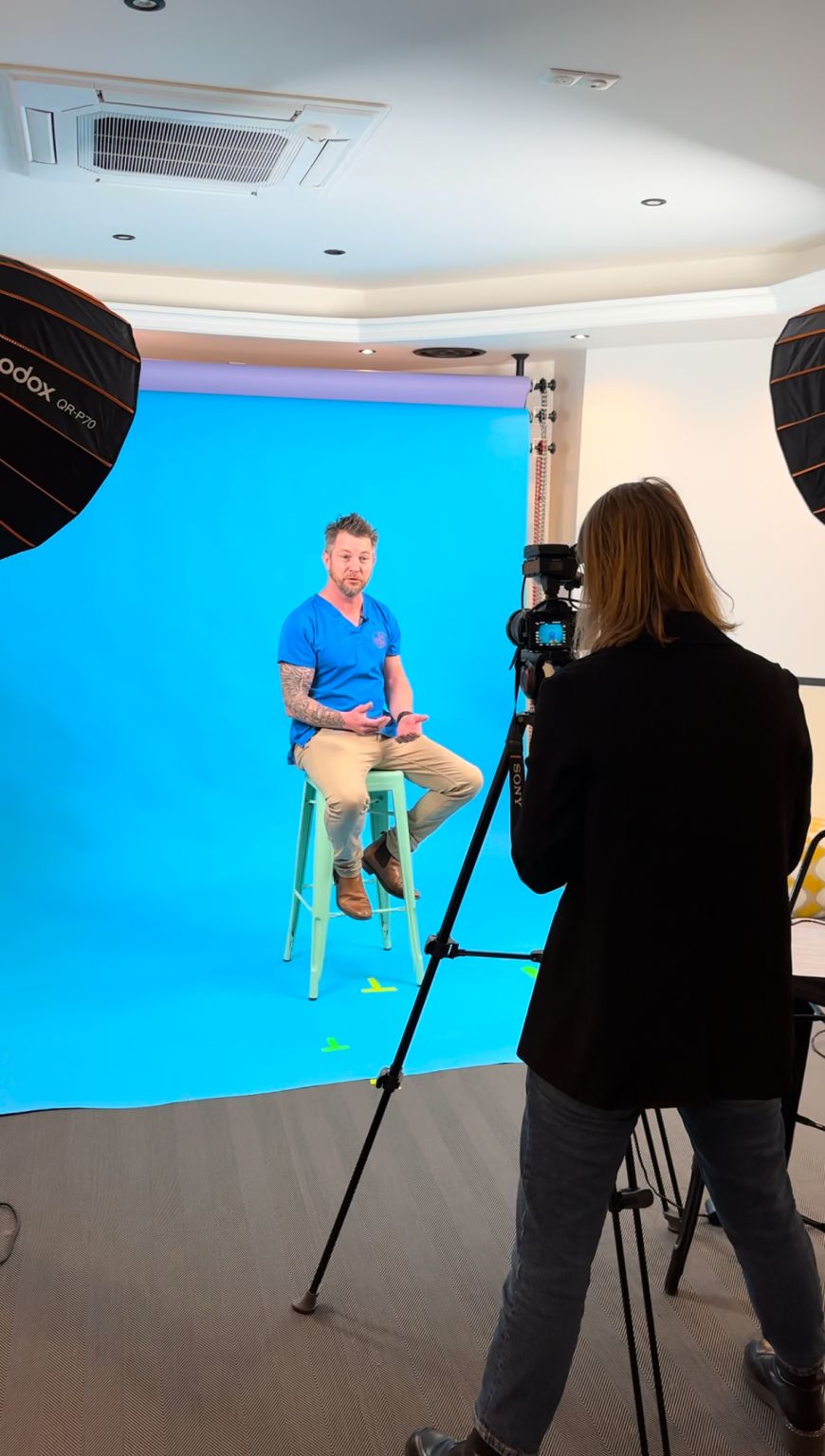 Tournage de Nico Veto en studio : caméra au premier plan, éclairage et fond bleu